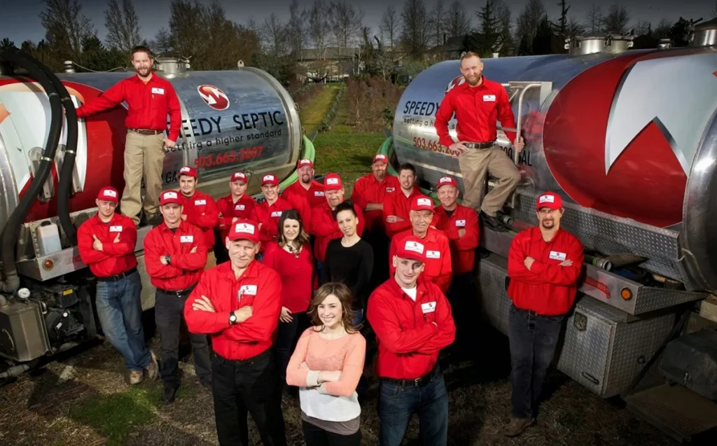 The Speedy Septic team gathered between their pump trucks.